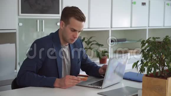 商人在现代办公室用信用卡在线支付视频的预览图