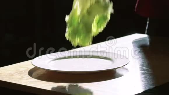 生菜色拉在黑色背景上用水滴落下和飞溅慢慢地视频的预览图