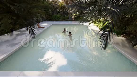 美丽的游泳池有洗澡的人在一个失落的热带岛屿上晴朗的晴天加载现实3D视频的预览图