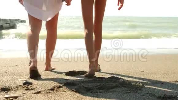 母女俩走在海边溅起水花在脚上动作缓慢波浪把两腿合拢视频的预览图