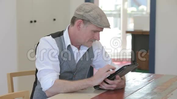 一个人坐在餐厅的桌子上拿着他的平板写字视频的预览图