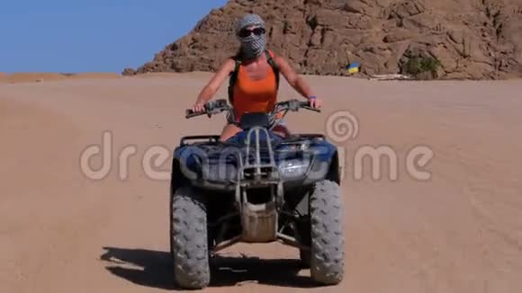 在埃及沙漠山脉背景下乘坐四驱车的女孩视频的预览图