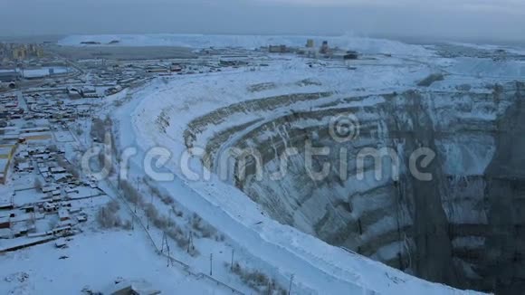 北部景观背景下大型露天矿坑危险地点附近房屋视频的预览图