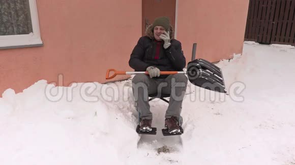 轮椅上的残疾人拿着雪铲在智能手机上讲话视频的预览图