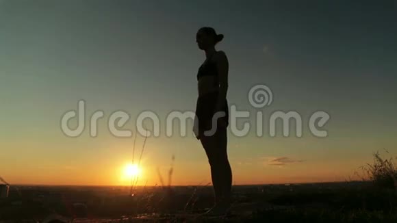 日落时分在公园练习瑜伽的女人舞蹈姿势之王视频的预览图