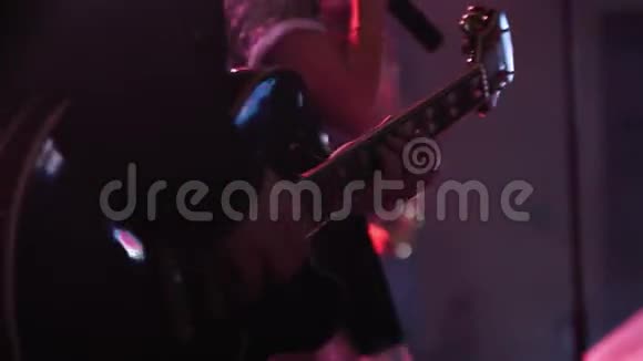 吉他手演奏的特写镜头在他的乐器上直播在一个乐队的背景上有女声歌手视频的预览图