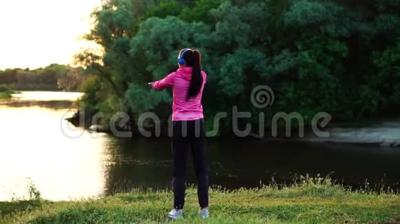 在训练准备在阳光下跑步之前女孩一大早就暖和起来视频的预览图