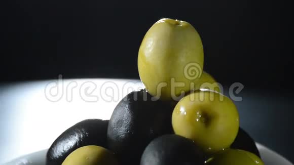 橄榄果绿色和黑色在黑色背景上旋转视频的预览图