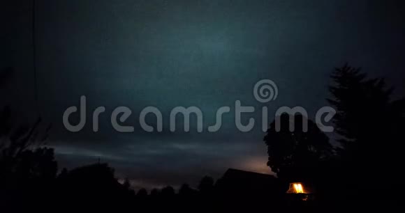 在冬夜星星在树上的时间推移然后云在黑暗的天空上出现视频的预览图
