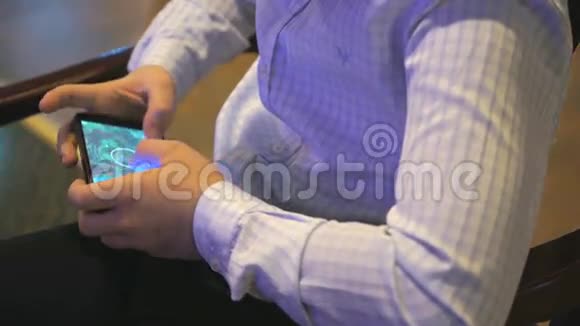 在智能手机上玩电脑游戏的男孩视频的预览图