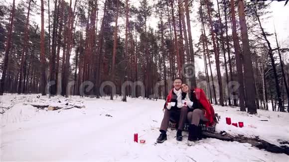 年轻的恋人在冬天的森林里玩得很开心视频的预览图