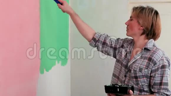 人用绿色油漆辊涂墙面视频的预览图