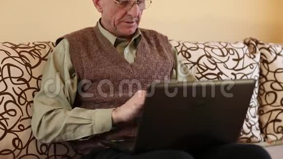 高级男性使用笔记本电脑键入文本视频的预览图
