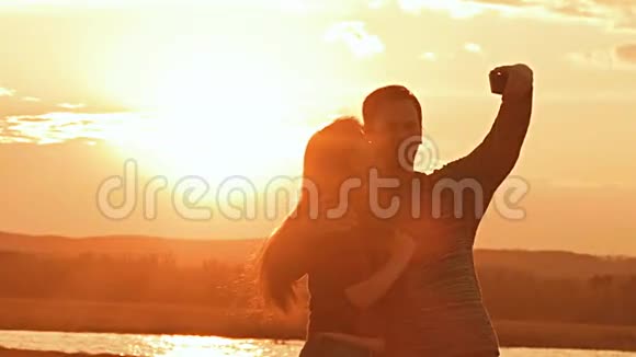 一对夫妇在日落的背景下拍摄慢动作视频视频的预览图