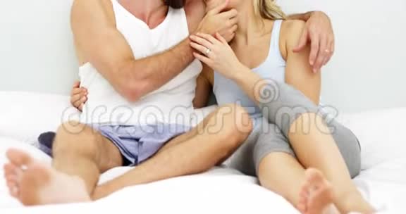 可爱的一对夫妇坐在床上互相抱着视频的预览图