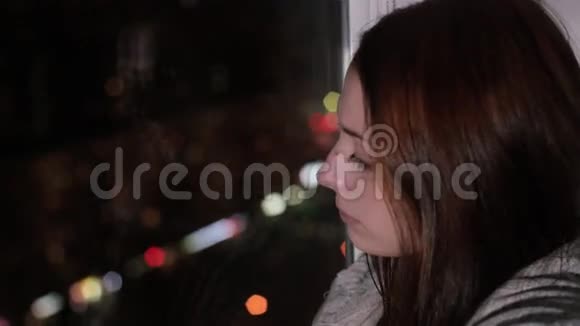 伤心的红发女人坐在窗台上哭泣视频的预览图