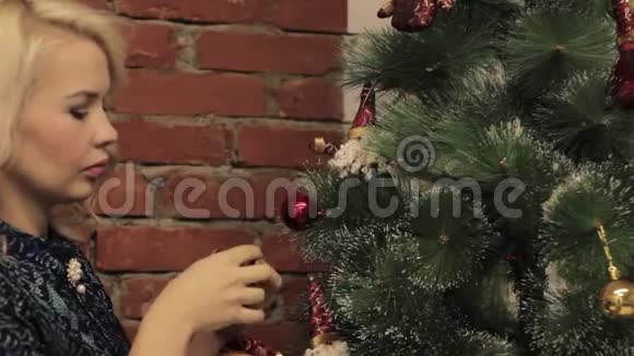 女人用圣诞玩具装饰圣诞树视频的预览图