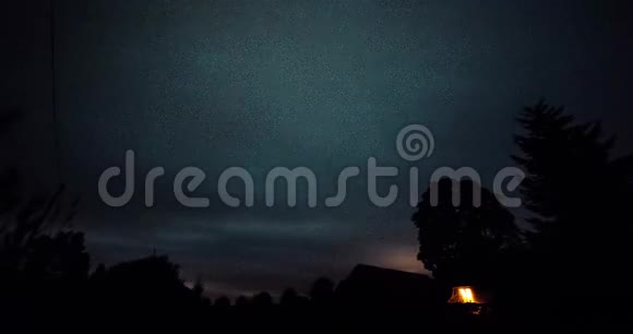 在冬夜星星在树上的时间推移然后云在黑暗的天空上出现视频的预览图