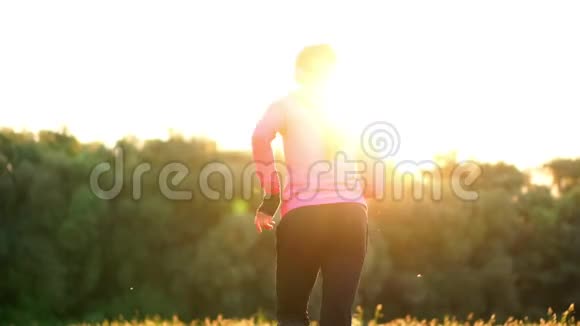 在训练准备在阳光下跑步之前女孩一大早就暖和起来视频的预览图