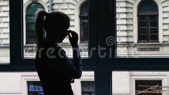 一个忙碌的女商人站在窗前视频的预览图