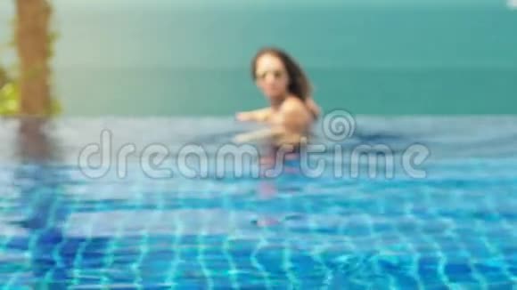 年轻女子在异国情调的游泳池里享受视频的预览图