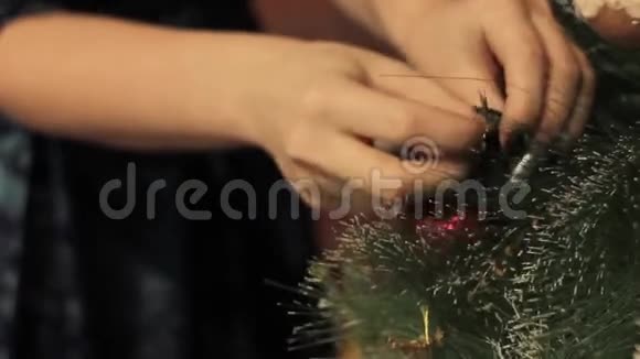 女人用圣诞玩具装饰圣诞树视频的预览图