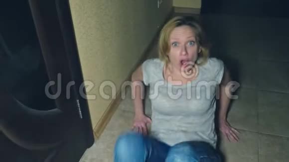 恐怖一个女孩从她的调查员那里爬开掉到她家走廊的地板上视频的预览图