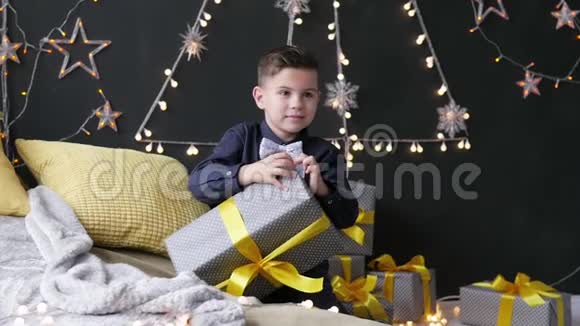 男孩在花环的背景下展开圣诞礼物视频的预览图
