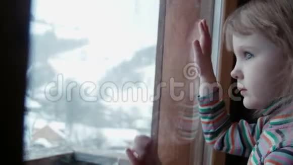 冬天窗后的小可爱女孩视频的预览图