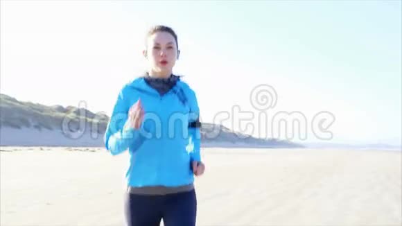 有决心的女人在海滩上慢跑的慢动作录像视频的预览图
