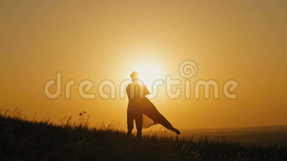 浪漫的男人跪在膝盖上向高山上的女人求婚的剪影夫妻在日落时订婚视频的预览图