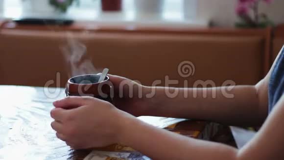 一个女孩喝着一个热气腾腾的早晨视频的预览图