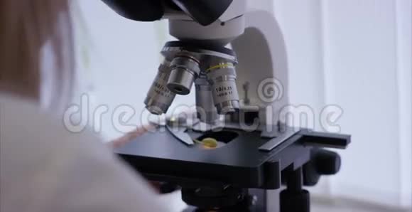 在实验室研究化学元素的严重临床医生显微镜镜头的特写显微镜玻片样品视频的预览图