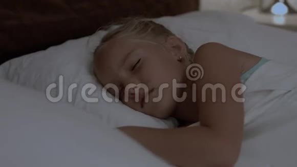 可爱的小女孩睡在床上视频的预览图