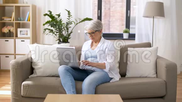 快乐的老女人在家打手提电脑视频的预览图