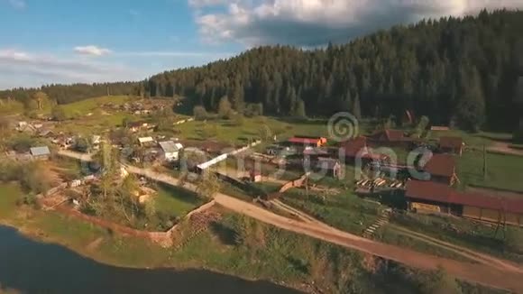 从森林附近的河流和村庄的高度鸟瞰视频的预览图