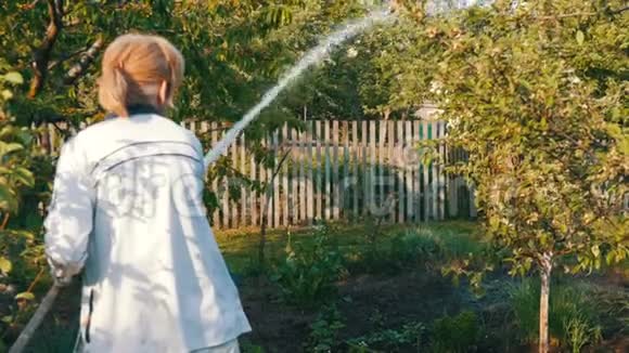 一个女人在自家花园里用水管浇水视频的预览图