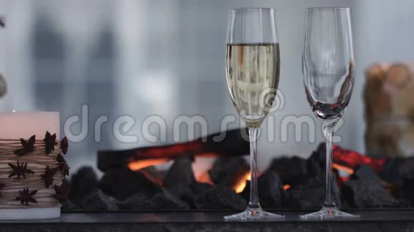 在温暖的壁炉前酒杯里闪烁着香槟酒关门视频的预览图