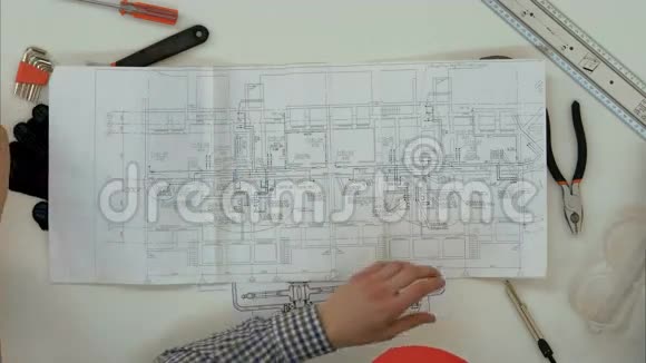 年轻建筑师用隔板和直尺检查图纸尺寸视频的预览图
