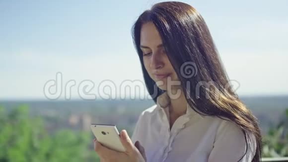 阳光明媚的一天美丽的黑发女人在地平线上打电话视频的预览图