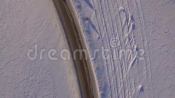 鸟瞰雪域和道路越野车在冬天的道路上行驶穿过雪地汽车的鸟瞰图视频的预览图