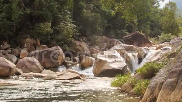 岩石树从暴风瀑布到透明河的景色视频的预览图