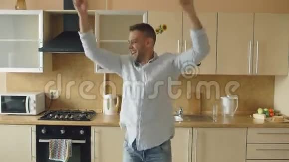 一个英俊的年轻人一个有趣的人早上在厨房里跳舞在节日里玩得开心视频的预览图