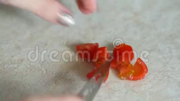 女人的手把樱桃番茄切成碎片视频的预览图