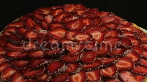 很多红切草莓在黑色的背景上慢慢地逆时针旋转视频的预览图