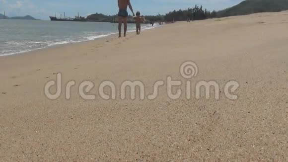 爸爸和宝宝去海滩波浪翻滚上岸海滩是光滑的沙子视频的预览图