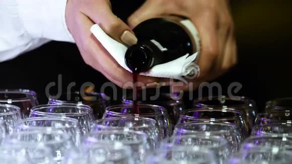 年轻的女侍酒师带着漂亮的指甲设计正在斟满透明的酒杯视频的预览图