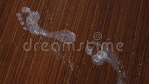 白色的女性脚印从脚上踩在木地板上的粘土粉视频的预览图