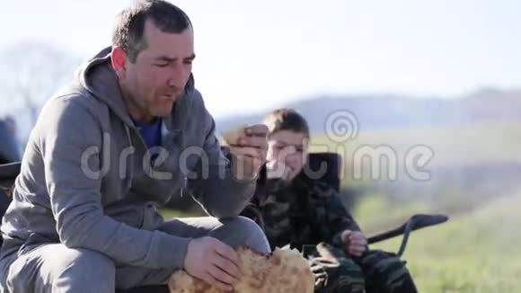 一家人父子在篝火旁吃烤面包视频的预览图