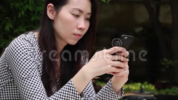 亚洲女人在花园里打电话聊天视频的预览图
